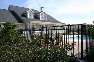 Home swimming pool in Rockwall surrounded by a wrought iron fence